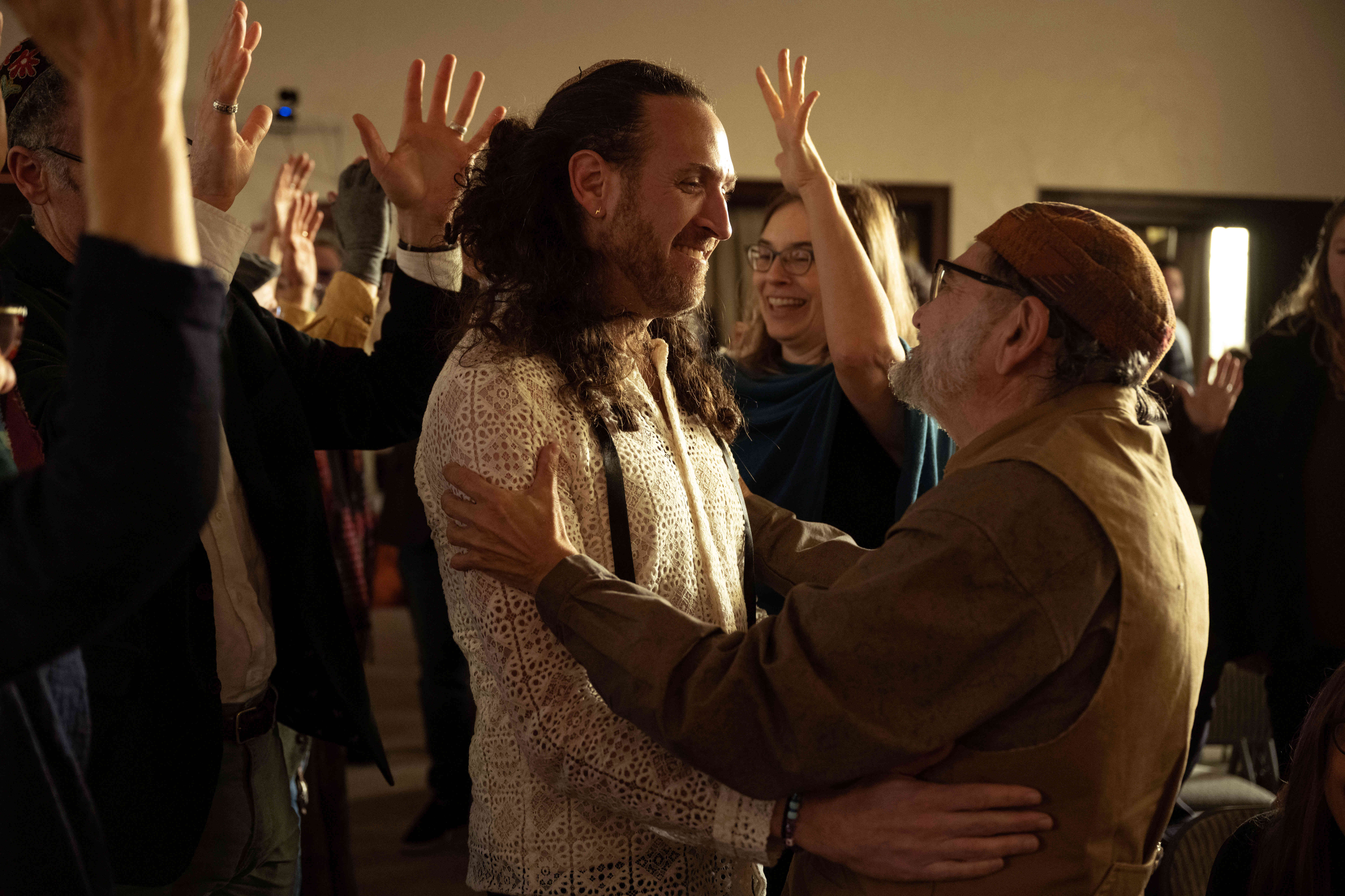 Rabbi David Cooper (right) holds Rabbi Zvika Krieger as he passes him down a line of spiritual leaders during a celebration for Krieger’s rabbinic ordination and installation at the Renewal synagogue Chomat HaLev in Berkeley on Saturday, Jan. 25, 2025. (Aaron Levy-Wolins/J. Staff)