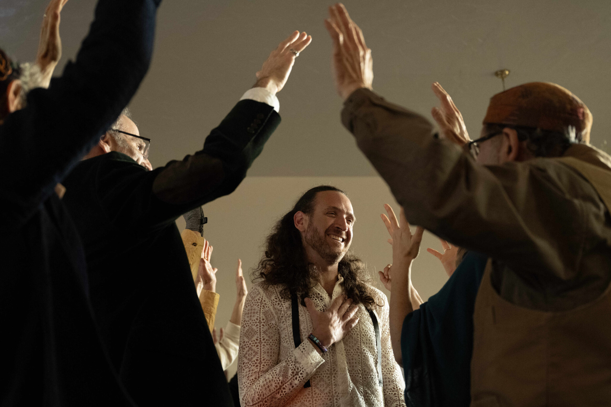 Rabbi Zvika Krieger (center) passes under the hands of rabbinic and spiritual leaders during a celebration for Krieger’s rabbinic ordination and installation at the Renewal synagogue Chomat HaLev in Berkeley on Saturday, Jan. 25, 2025. (Aaron Levy-Wolins/J. Staff)