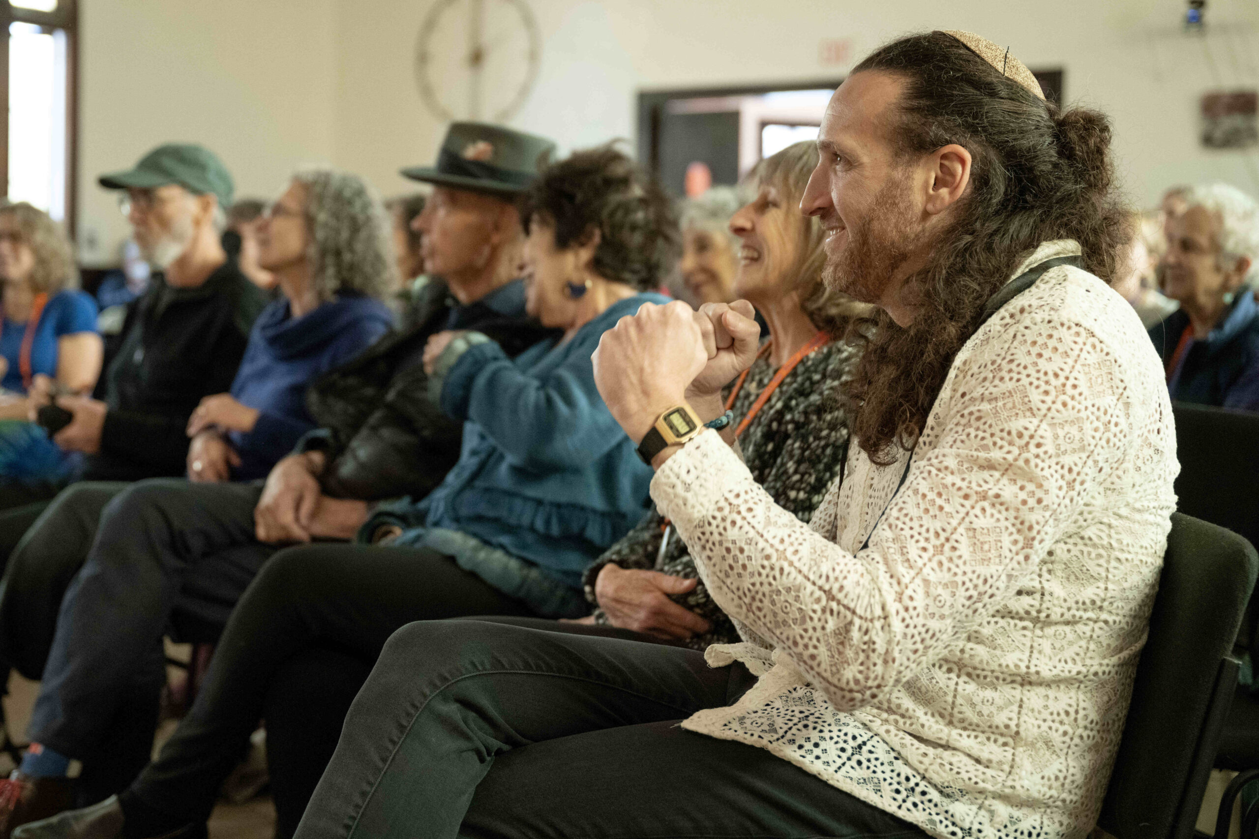 Zvika Krieger dances in his seat during a celebration for Krieger’s rabbinic ordination and installation at the Renewal synagogue Chomat HaLev in Berkeley on Saturday, Jan. 25, 2025. (Aaron Levy-Wolins/J. Staff)